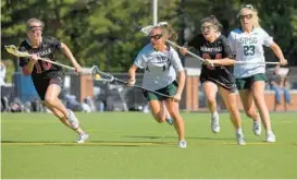  ?? FERRON/BALTIMORE SUN KARL MERTON ?? St. Paul’s midfielder Caroline Hoskins carries the ball between Maryvale midfielder Sam Paradise, left, and defender-midfielder Elizabeth Garcia as midfielder Anna Regan watches during an IAAM A Conference semifinal at Rosalind R. Levering Field on Tuesday.