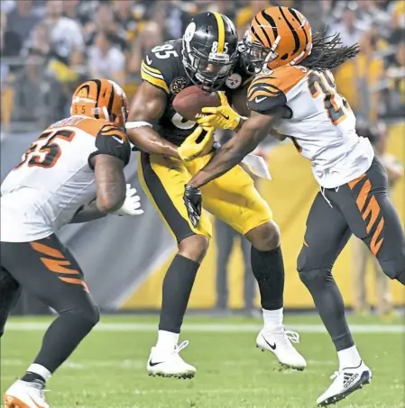  ?? Matt Freed/Post-Gazette ?? Steelers tight end Xavier Grimble pulls in a ball against the Bengals’ Vontaze Burfict and Josh Shaw earlier this season against Cincinnati at Heinz Field.