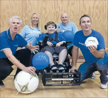  ??  ?? Nick Redstone, right, helps grant the wish of Brennan Massey, 12, who wanted a Strike Force football sports chair.