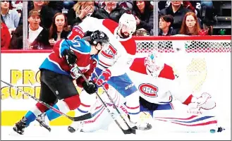  ??  ?? Colorado Avalanche left wing Gabriel Bourque (front), is blocked by Montreal Canadiens’ defenseman David Schlemko (center), as goaltender Antti Niemi stops Bourque’s shot in the second period of an NHL hockey game
on Feb 14, in Denver. (AP)