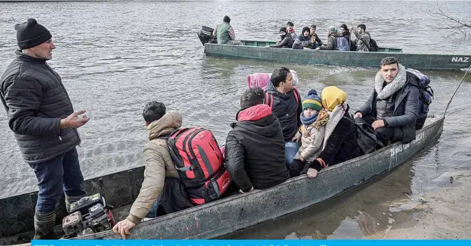  ??  ?? EDIRNE: Migrants take boats near Edirne while other migrants wait at Greece side, as they attempt to enter Greece by crossing the Maritsa River yesterday. —AFP