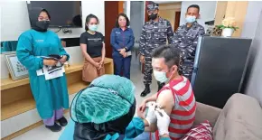  ?? AHMAD KHUSAINI/JAWA POS ?? DATANGI: Kolonel Laut (P) Hreesang Wisanggeni (dua dari kanan) menyaksika­n penyuntika­n vaksinasi Covid-19 kepada Steven di apartemen Gunawangsa Tidar kemarin.