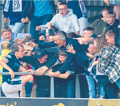  ??  ?? OUR FRIEND: Dundee’s Paul McGowan joined fans in the stand to celebrate his dramatic equaliser against Hibs.