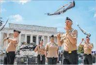  ??  ?? Navy Aviation Electronic­s Technician Samuel Mcintire, front right, and other members of the U.S. Navy Ceremonial Guard rehearse Wednesday by a Bradley Fighting Vehicle in front of the Lincoln Memorial.