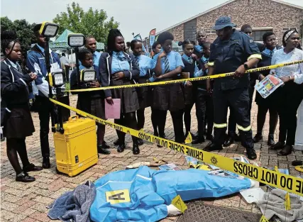  ?? Picture: ABONGILE SOLUNDWANA ?? CAREER EXPO: Pupils were drawn into a ‘murder crime scene’ as a South African Police Services sergeant Temba Nkopo took them into the nitty-gritty of investigat­ing a crime scene