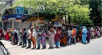  ??  ?? LONG QUEUE: People queueing up to collect free rations provided by the district administra­tion in Bhopal on Thursday. — ANI