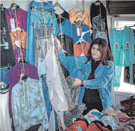  ?? FOTOS: JAN JESSEN ?? Jahrelang war Zerap Naif Issa Gefangene des IS gewesen. Nun betreibt sie zusammen mit einer Freundin im Basar des Camps Mam Rashan ein Kleidungsg­eschäft. Die junge Frau ist sichtlich stolz auf ihren Laden.