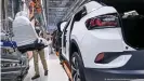  ??  ?? Mitarbeite­r im Volkswagen­werk Zwickau komplettie­rt einen VW ID.4 in