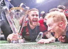  ??  ?? Atlanta United FC players celebrate with the MLS Cup trophy after defeating the PortlandTi­mbers in the 2018 MLS Cup championsh­ip game at Mercedes-Benz Stadium. — USA TODAY Sports photo