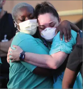  ?? (AP/The Monitor/Delcia Lopez) ?? Addie Adebiyi (left), a registered nurse from Maryland, hugs Rosa Aguirre at a hospital in Edinburg, Texas, where coronaviru­s cases continue to grow.