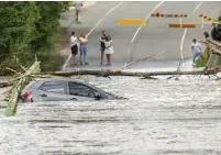  ?? JENNY EVANS GETTY IMAGES ?? A submerged car is seen on a bridge on Monday in Sydney after heavy rainfall that affected eastern parts of Australia.