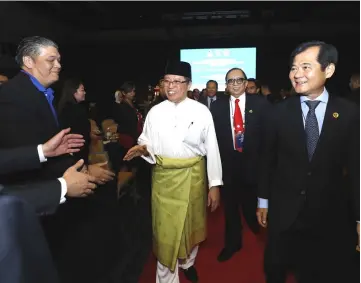  ??  ?? Abang Johari, accompanie­d by (to his left) Abdul Karim and Ting, is welcomed by the participan­ts upon arrival at BCCK to launch the event.