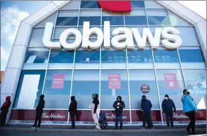  ?? The Canadian Press ?? People wait in a line to receive a COVID-19 vaccine at a Loblaws grocery store pharmacy in Ottawa on April 26.