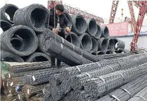  ??  ?? A worker loads steel products on to a vehicle at a steel market in Fuyang in central China’s Anhui province on Friday, March 2. China has expressed “grave concern” about a US trade policy report that pledges to pressure Beijing with tariffs.