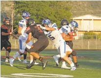  ?? JESSE MOYA/TAOS NEWS ?? St. Michael’s Lucas Montoya, center, blocks for running back Rico Gurule against Taos’ Angel Polanco in Friday’s season opener at Anaya Field. The Tigers won 33-19.