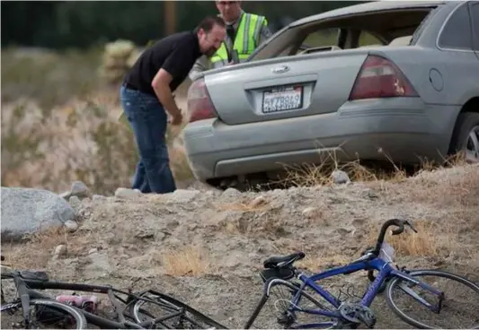  ??  ?? California Highway Patrol investigat­ors inspect a vehicle that struck two cyclists participat­ing in the 2018 Tour de Palm Springs near Indio Hills on Saturday. Police say the car seen was driving down a road at twice the speed limit colliding into...