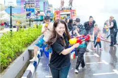  ??  ?? All around SugarBun Sibu Jaya, the site of the water fiesta, people are seen laughing and squealing as they engage in water fights with each other.