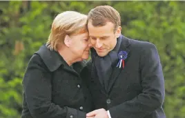  ??  ?? SHARED SORROW. President Emmanuel Macron and German Chancellor Angela Merkel hug after unveiling a plaque yesterday.