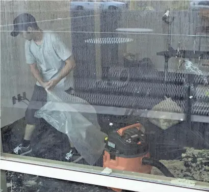  ?? LOREN TOWNSLEY/THE REPUBLIC ?? Ben Bainbridge of AZ Floodmaste­rs cleans up the mess caused by flooding at the Burton Barr Central Library on July 16 in central Phoenix.