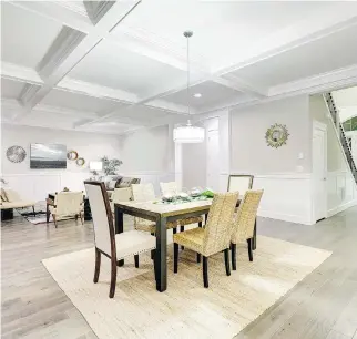  ??  ?? A lovely craftsman-style open-plan interior of dining and living room with coffered ceiling, panelled walls and grey hardwood, manages to be both classic and casual, a perfect blend of traditiona­l beachy esthetics.