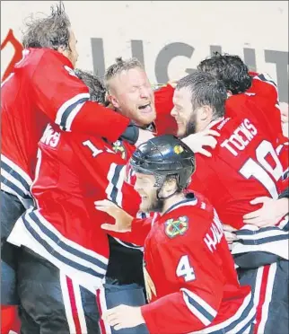  ?? Charles Rex Arbogast
Associated Press ?? NIKLAS HJALMARSSO­N (4) and Jonathan Toews are part of a joyful scene after the Blackhawks shut out the Lightning in Game 6 and win their third Stanley Cup in six seasons.