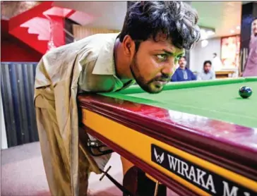  ?? AFP ?? Snooker was an unlkely passion for Muhammed Ikram, who was born with no arms, but he has spent years honing his craft and is a worthy opponent in any billiard hall.