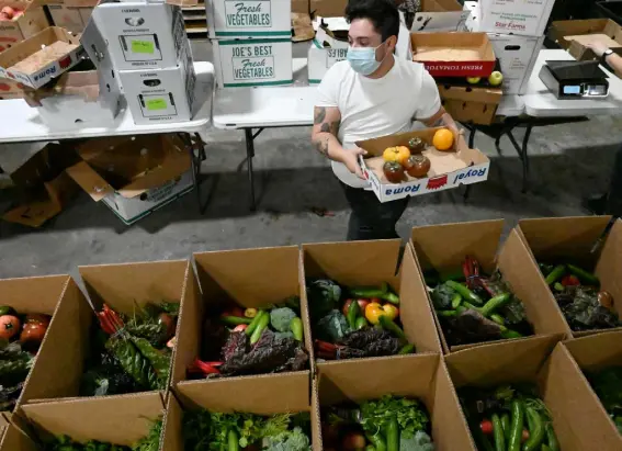  ?? RJ Sangosti, The Denver Post ?? Al Goodman packs boxes of produce on Nov. 23 for East Denver Food Hub, a local food distributi­on organizati­on that delivers fresh produce to people.