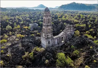  ?? (AP/Eduardo Verdugo) ?? A church tower on Feb. 21 peeks above from where lava from the Paricutin volcano buried the church decades ago in San Juan Parangaric­utiro, Mexico.