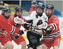  ?? RYAN PFEIFFER TORSTAR FILE PHOTO ?? A trio of Brooklin Lacrosse Club players attack Brandon Robinson during a Major Series Lacrosse game last summer.