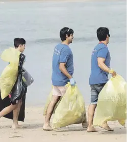  ??  ?? Voluntario­s en la playa de Punta Umbría (Huelva)