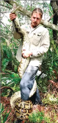 ?? ?? Easterling holds a 15-foot female Burmese python in February in Florida.