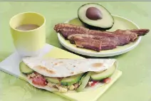  ?? RICHARD DREW/ THE ASSOCIATED PRESS ?? Avocado, onions and tomatoes are added to eggs to make breakfast tacos.