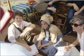  ?? NWA Democrat-Gazette photograph­s by Charlie Kaijo ?? Gavin Crawford, 11, and Gwen Crawford, 11, of Joplin, Mo., (from left) listened to Kathleen Bowen talk about her involvemen­t in the reenactmen­t culture Friday during the Civil war battle encampment.