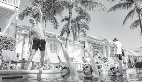  ??  ?? Peter Rogers teaches an aqua yoga class, put on hiatus during the coronaviru­s pandemic, Feb. 13 at the Marker Key West Harbor Resort in Key West, Florida.