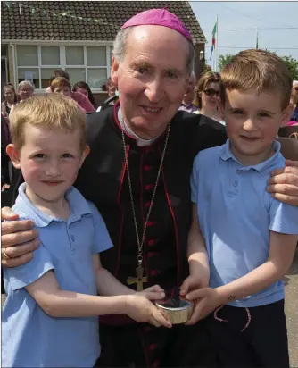  ??  ?? The youngest pupils in the school, Josh Fenlon and Oisín Croke, presenting Bishop Denis Brennan with personalis­ed rosary beads.