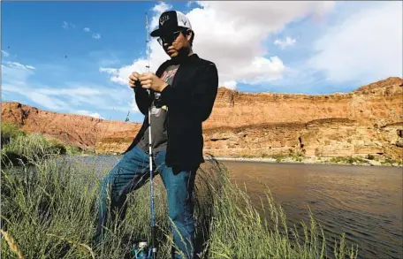 ?? Luis Sinco Los Angeles Times ?? A FISHERMAN sets up on the banks of the Colorado River as it cuts through the Navajo Nation en route to the Grand Canyon last year.
