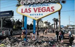  ?? JOHN LOCHER/AP ?? A memorial for victims of the mass shooting surrounds the Strip’s iconic welcome sign.