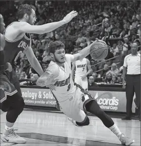  ?? PATRICK FARRELL/TRIBUNE NEWS SERVICE ?? Miami Heat's Tyler Johnson (8) drives past the Cleveland Cavaliers' Kevin Love (0) on Monday in Miami, Fla.