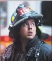  ?? Johannes Eisele / AFP/Getty Images ?? A firefighte­r looks up near a building where a helicopter crash-landed in midtown Manhattan in New York on Monday.