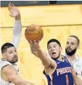  ?? JOHN RAOUX/AP ?? The Suns’ Devin Booker (1) misses a shot as he gets between the Magic’s Nikola Vucevic, left, and Evan Fournier, as time expired in the second half.