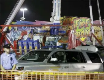  ?? BARBARA J. PERENIC — THE COLUMBUS DISPATCH VIA AP ?? Authoritie­s stand near the Fire Ball amusement ride after the ride malfunctio­ned injuring several at the Ohio State Fair, Wednesday in Columbus, Ohio. Some of the victims were thrown from the ride when it malfunctio­ned Wednesday night, said Columbus...