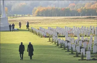  ?? Francisco Seco/Associated Press, Pool ?? British Prime Minister Theresa May, right, walks with French President Emmanuel Macron after they placed wreaths at the World War I memorial in Thiepval, France, on Friday. The memorial commemorat­es more than 72,000 British and South African forces who died during fighting in the Somme.