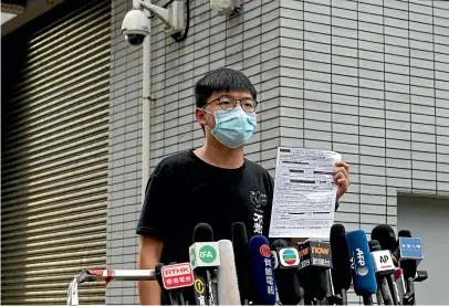  ?? AP ?? Hong Kong pro-democracy activist Joshua Wong displays a bail paper outside Central Police Station in Hong Kong.