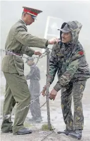  ?? (AFP) ?? Indian (right) and Chinese soldiers secure a barbed wire fence at the Nathu La border crossing in India’s Sikkim state