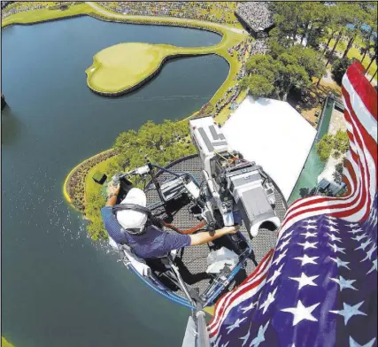  ?? John Boeddeker ?? Golf Channel cameraman John Boeddeker is seen from his perch high above the No. 17 green at TPC at Sawgrass in Ponte Vedra Beach, Fla.