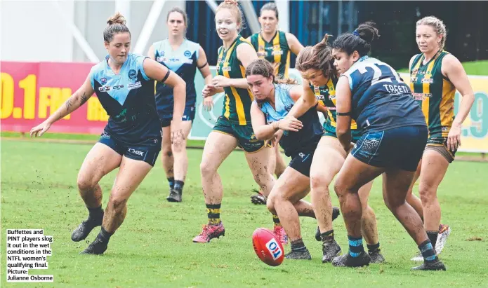  ?? Julianne Osborne ?? Buffettes and PINT players slog it out in the wet conditions in the NTFL women’s qualifying final. Picture: