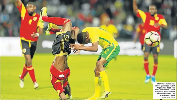  ?? Picture: ALAN EASON ?? ACROBAT: Bartolomeu Jacinto Quissanga (13) of Angola flies head over heels as Bafana’s Luther Singh (12) ducks in their friendly at Buffalo City Stadium last night