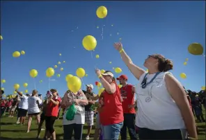  ?? (NWA Democrat-Gazette/Ben Goff) ?? Emily Marie Rogers (right) and her mother, Cindy Lee Rogers of Springdale, join others in releasing balloons during the annual Northwest Arkansas Out of the Darkness Community Walk in 2016 at Orchards Park in Bentonvill­e. The balloons were released in memory of loved ones who died by suicide.