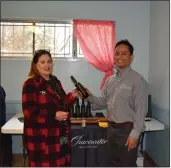  ?? COURTESY PHOTO ?? Garden Club Vice President, Dana Benjamin, exchanges olive oil and advice from Mill Master Emilio De La Cruz, of Chacewater Winery & Olive Mill.