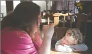  ??  ?? Link Nieman, 4, watches as mom Alissa Nieman, of Acampo, tastes tea at Tea-Tasting in downtown Lodi.